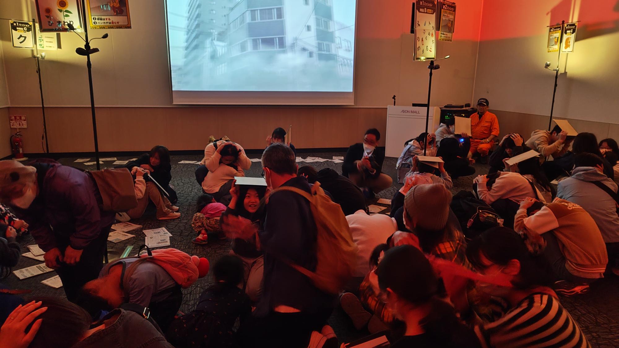 体験型防災イベントで身を守 る行動を行う様子