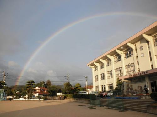川上小学校の校舎と虹が写っている写真の画像