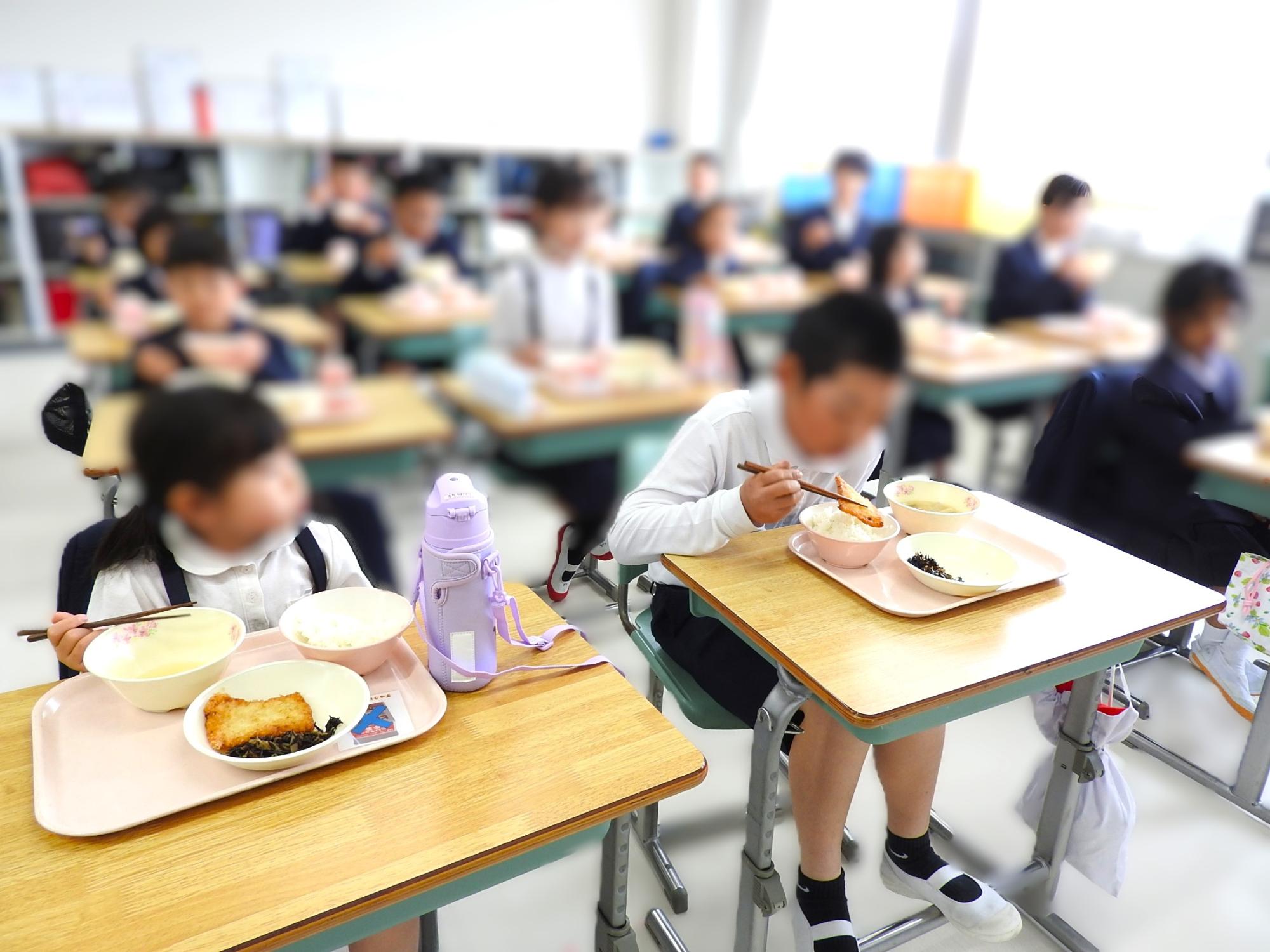 1年生教室で6年生が1年生と一緒に給食を食べる様子1