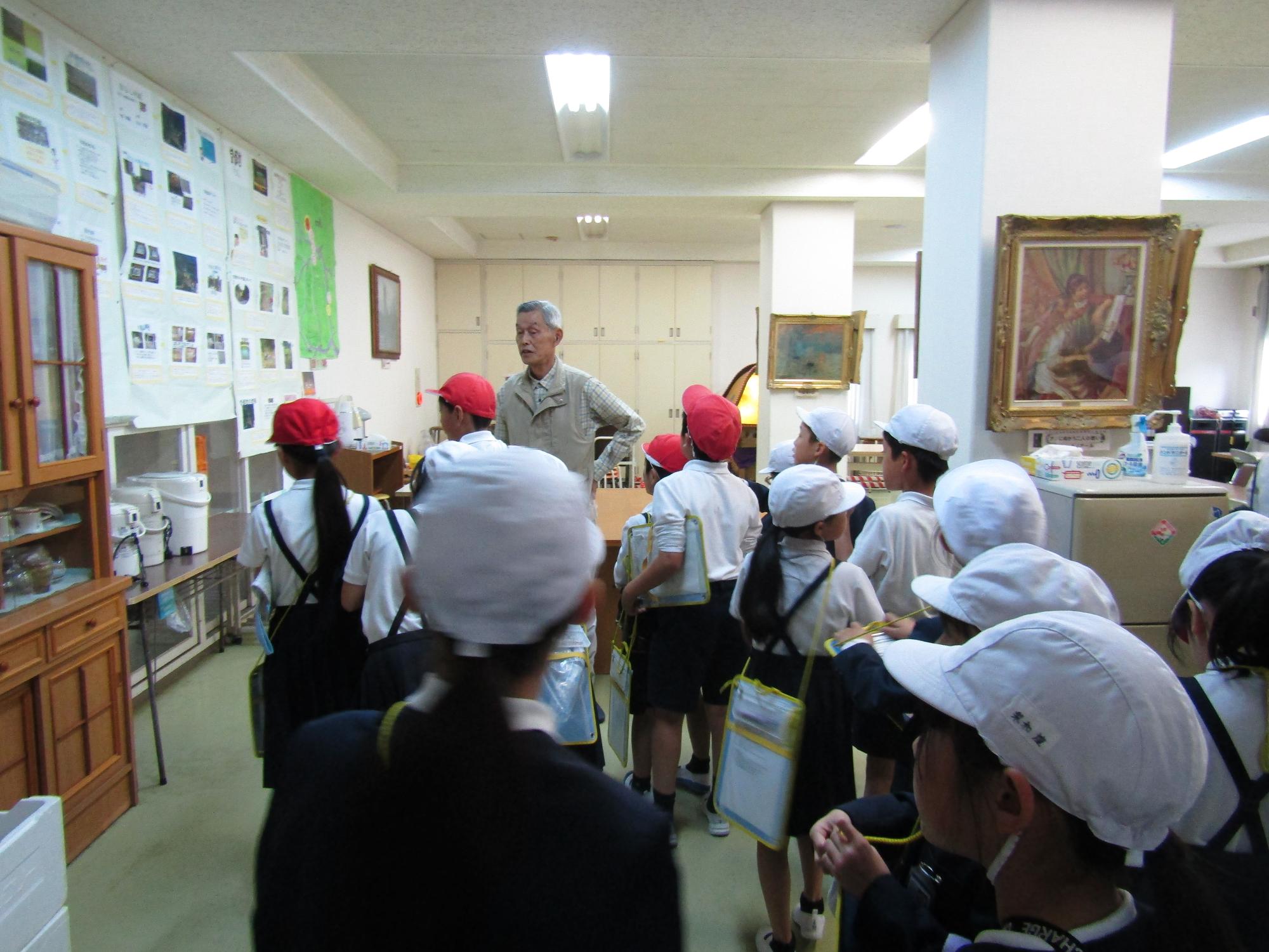 建物の中で地域住民の話を聞く子供達
