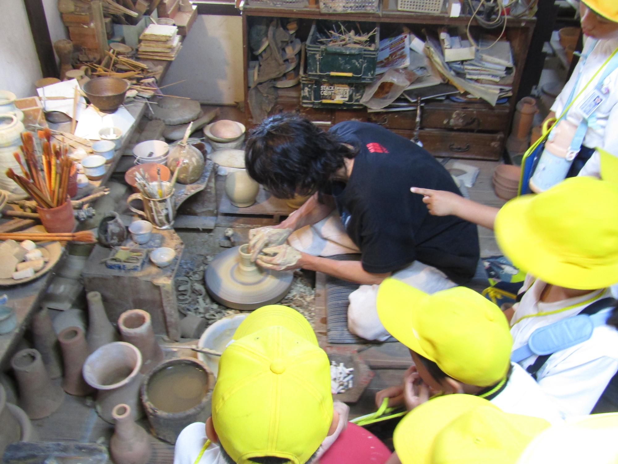 ろくろを回して作る作業を見守る子供達