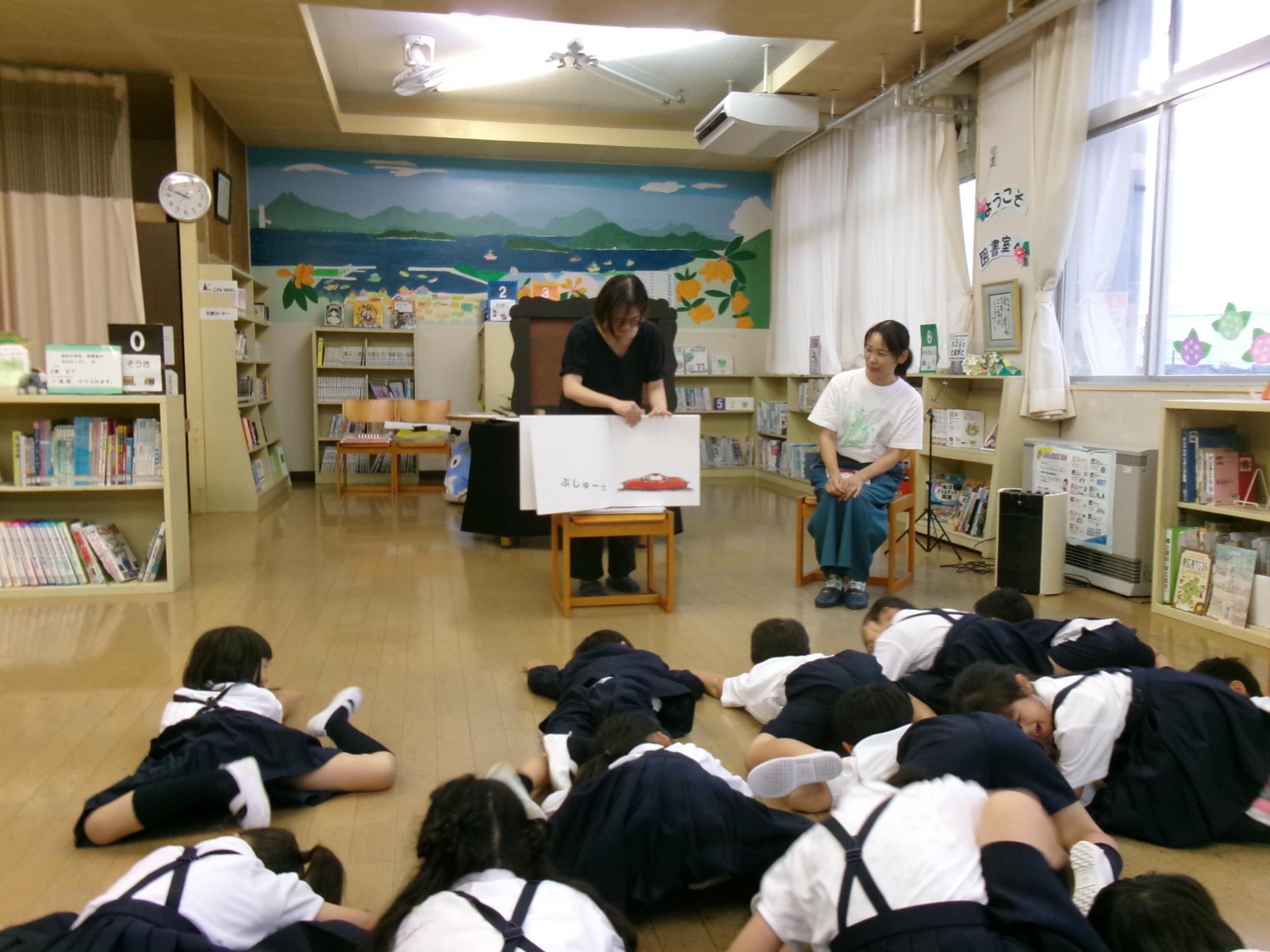 絵本と同じポーズで寝そべる子供達