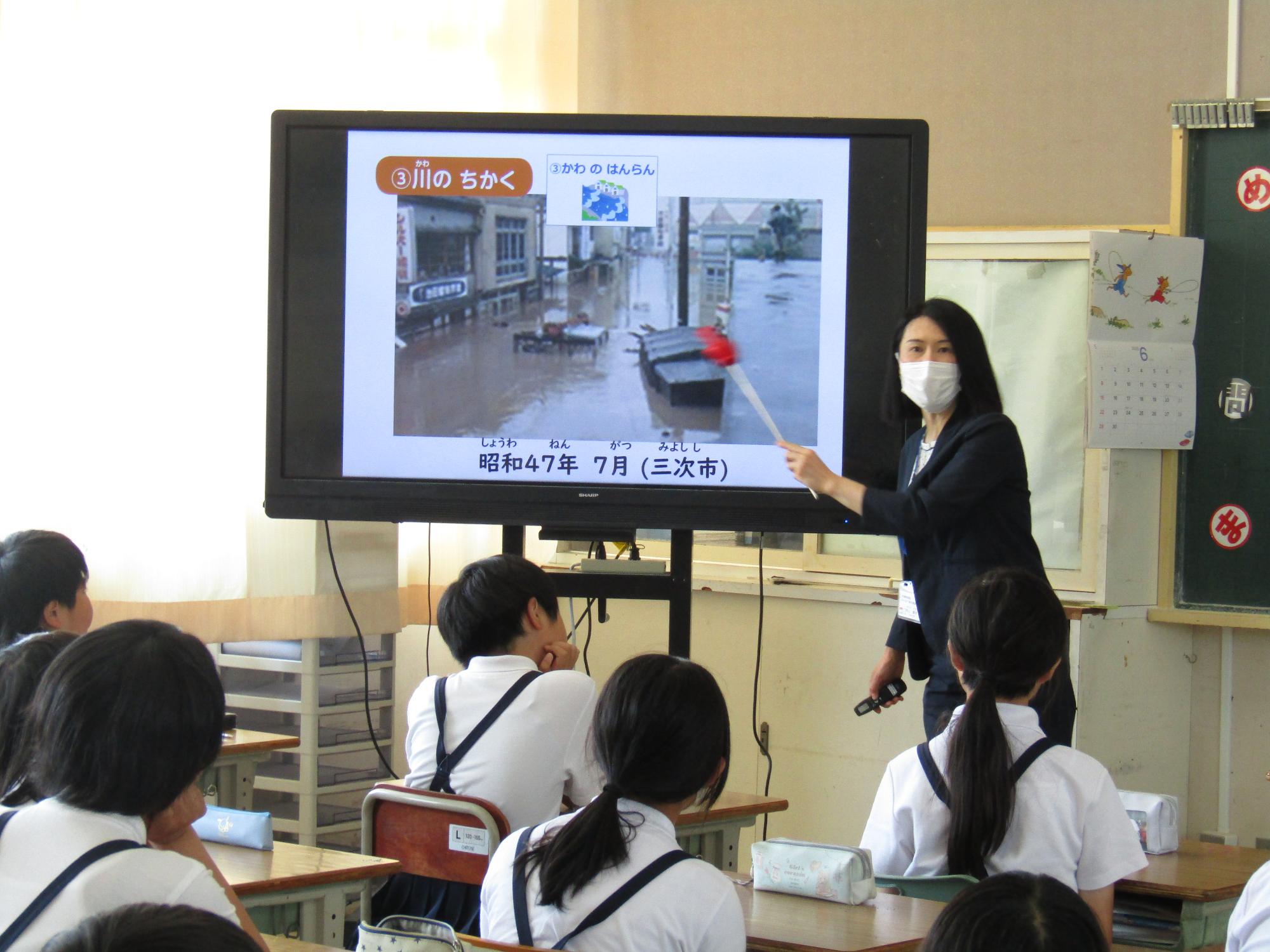 電子黒板に表示された写真を開設する井上さん