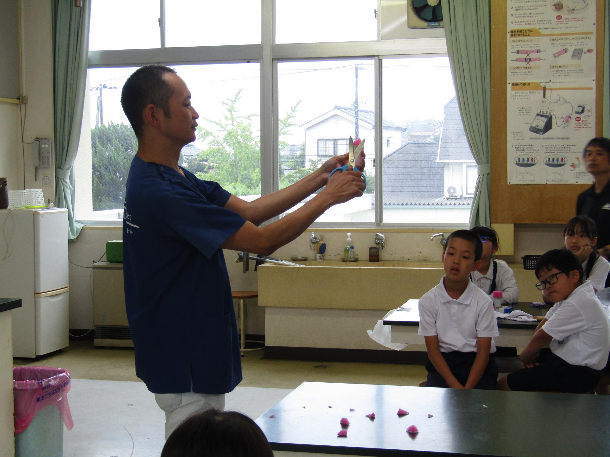 はさみでスポンジを切る男性