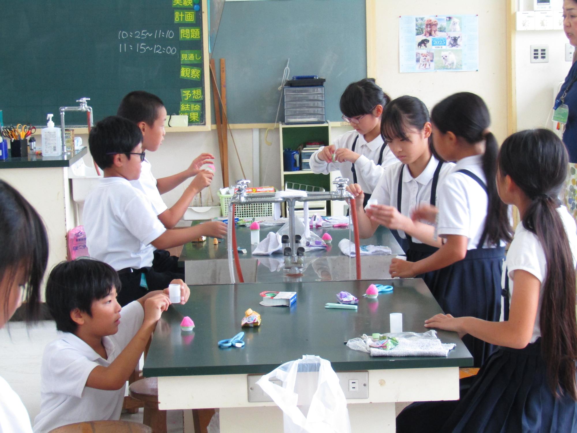 机を囲んでミニロケットを作る子供たち