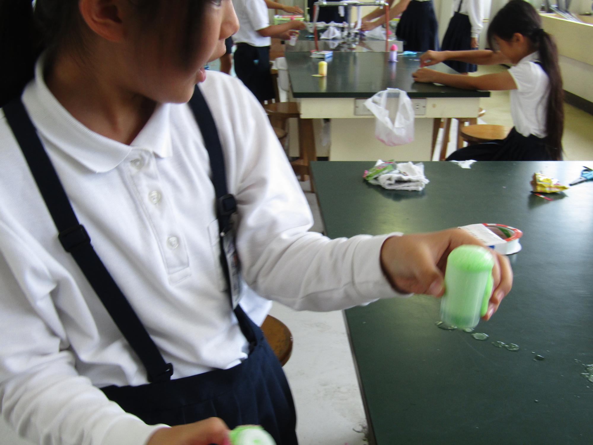 入浴剤の泡があふれるケースを持つ女子児童