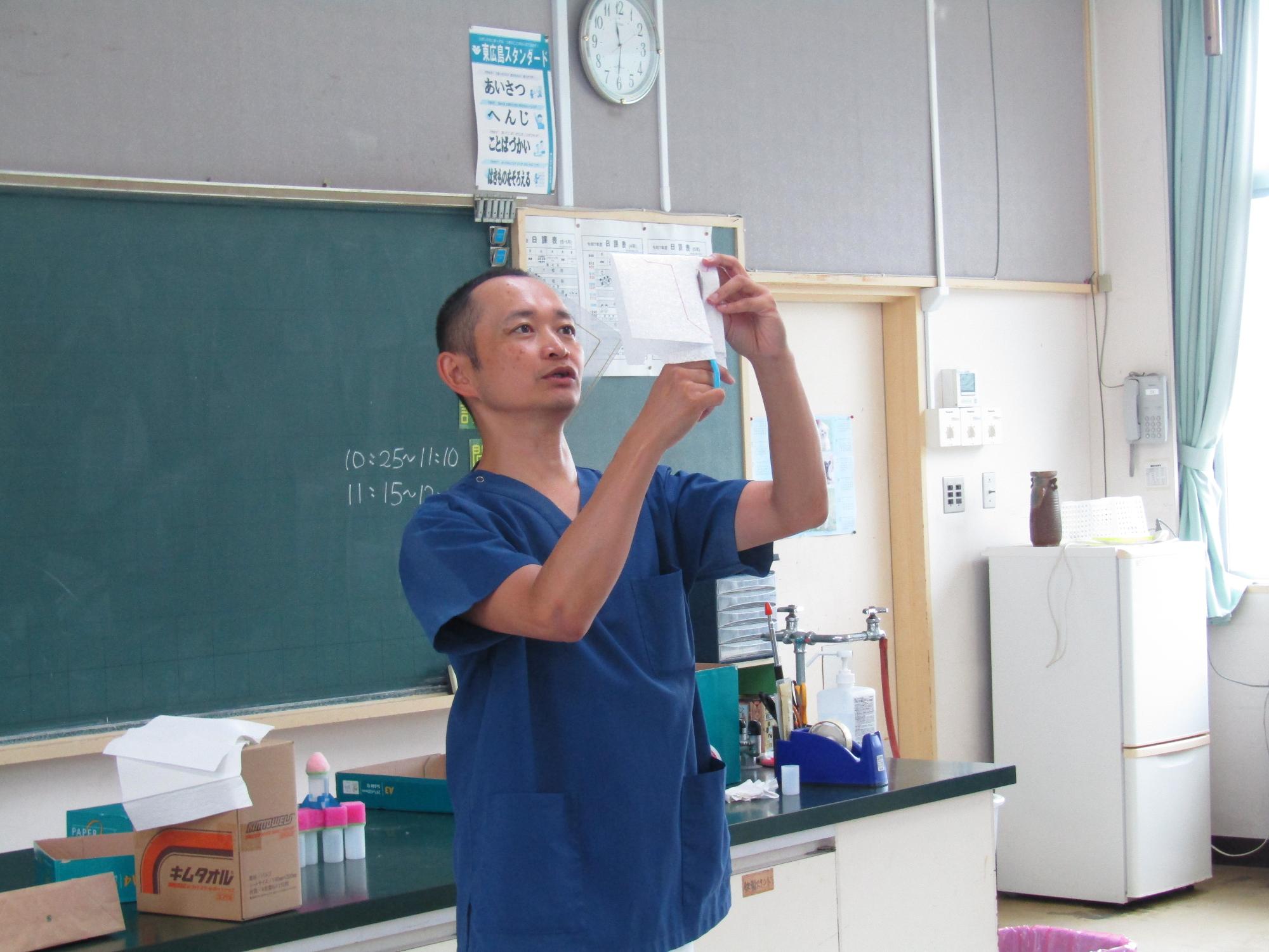 紙飛行機を切る男性