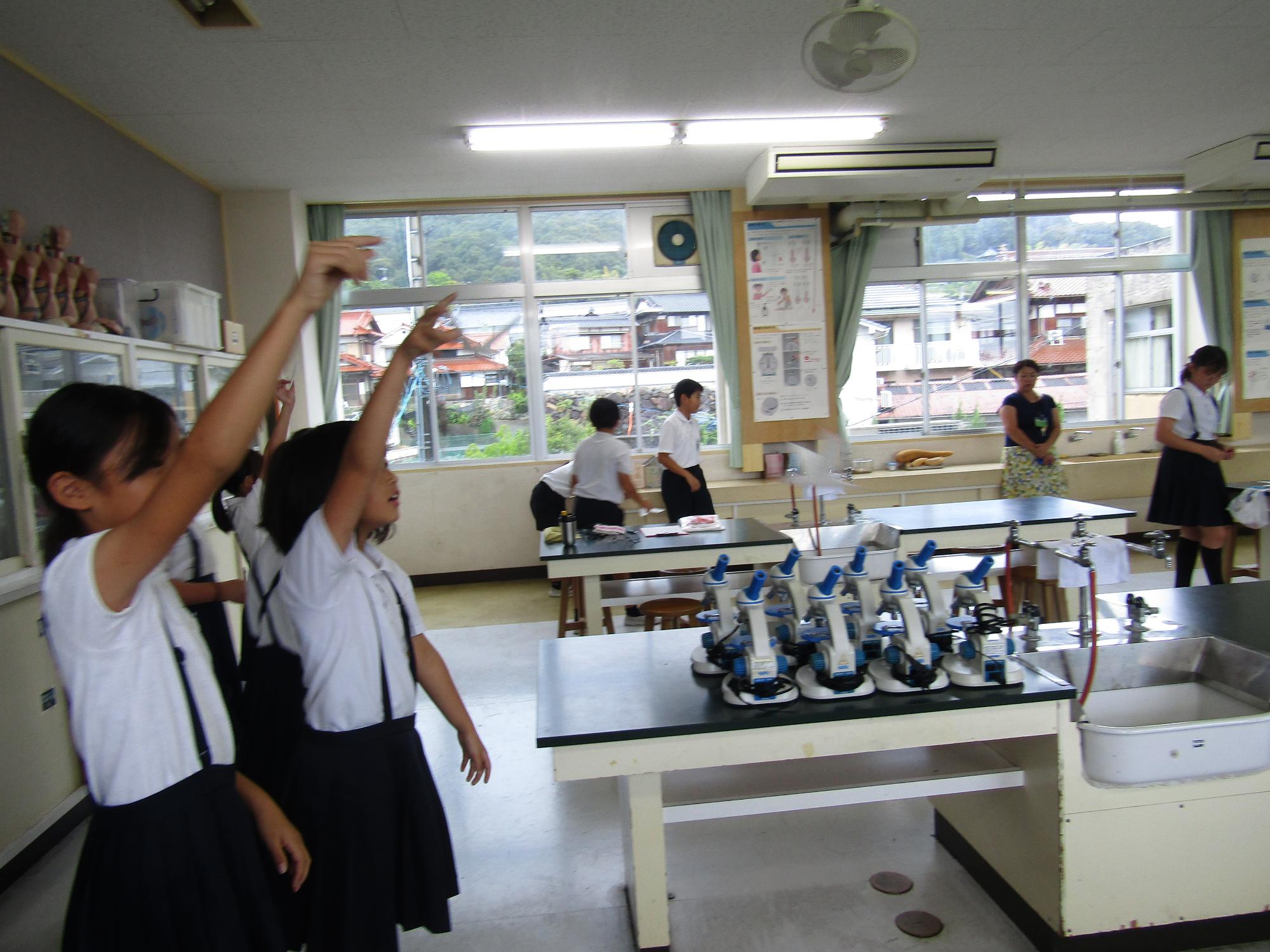 友達と並んで紙飛行機を飛ばす女子児童たち