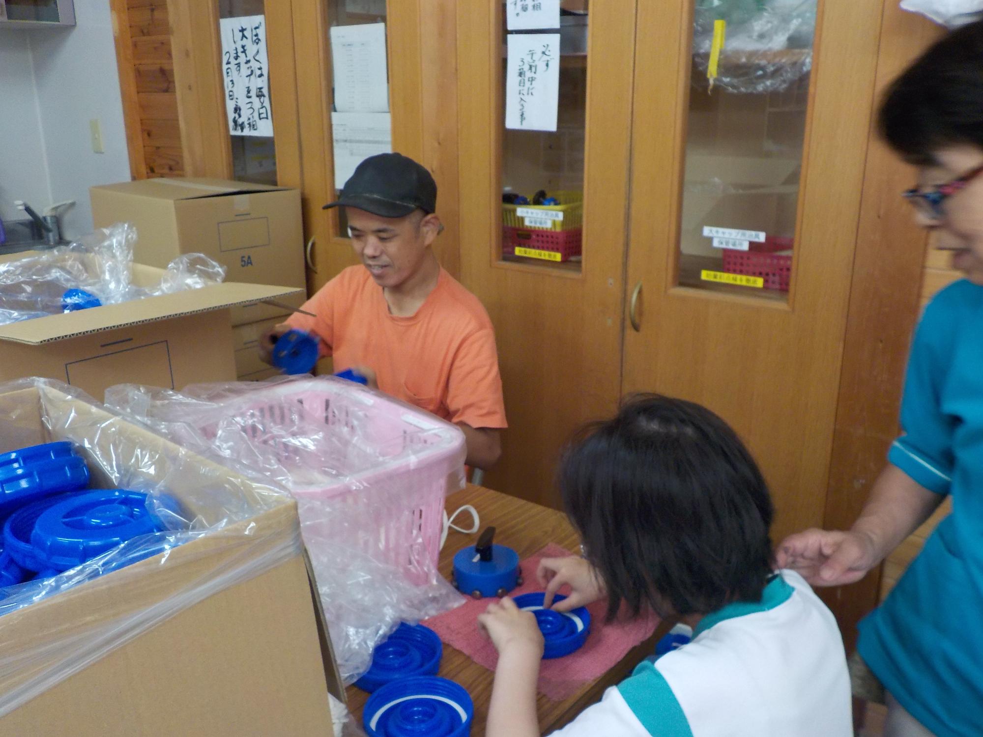 利用者さんと並んで仕事をする女児児童