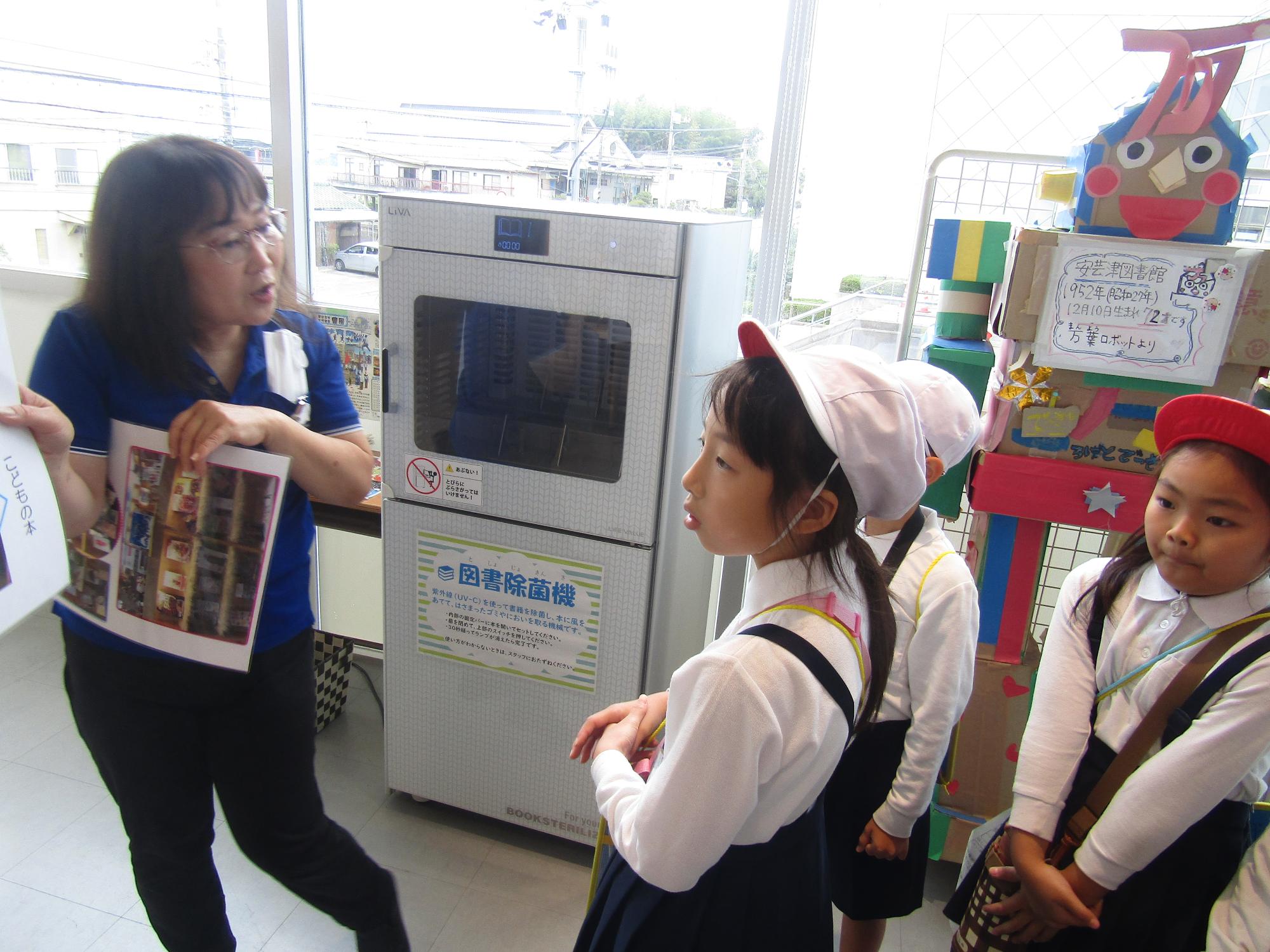 図書館内でスタッフから話を聞く児童たち