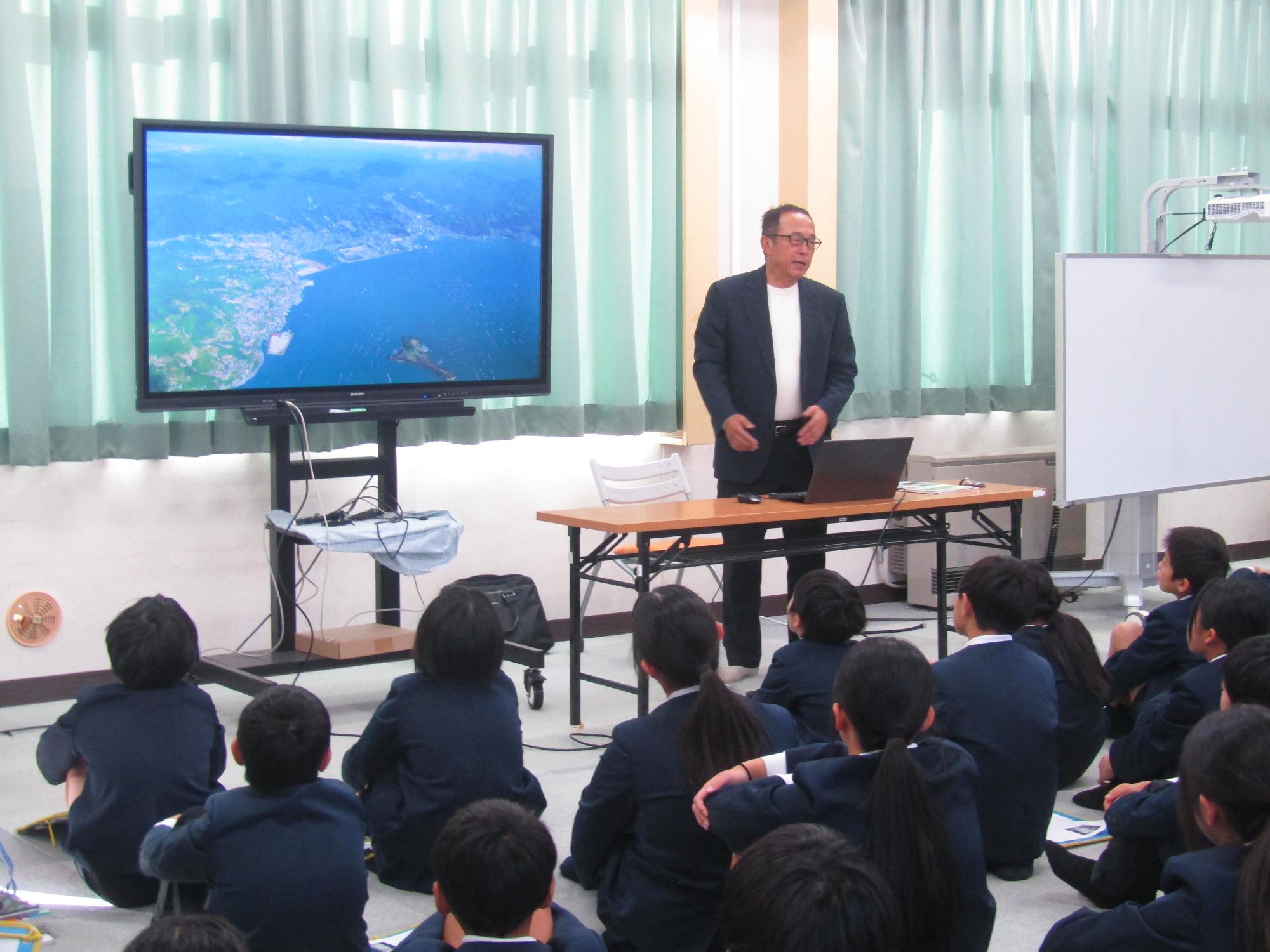 スライドショーを使って風早の歴史について話す男性