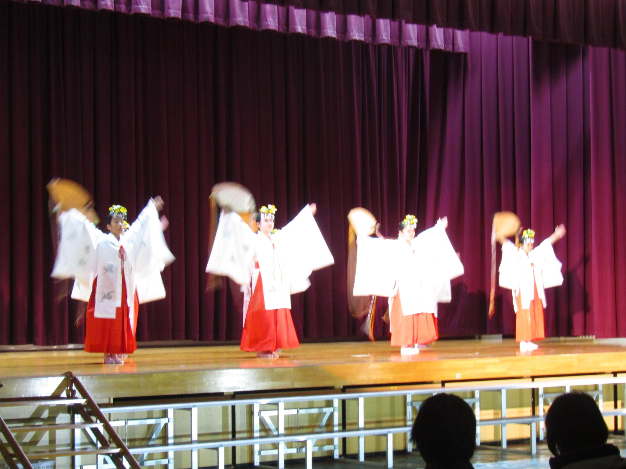 ステージ上で巫女たちが舞っている様子