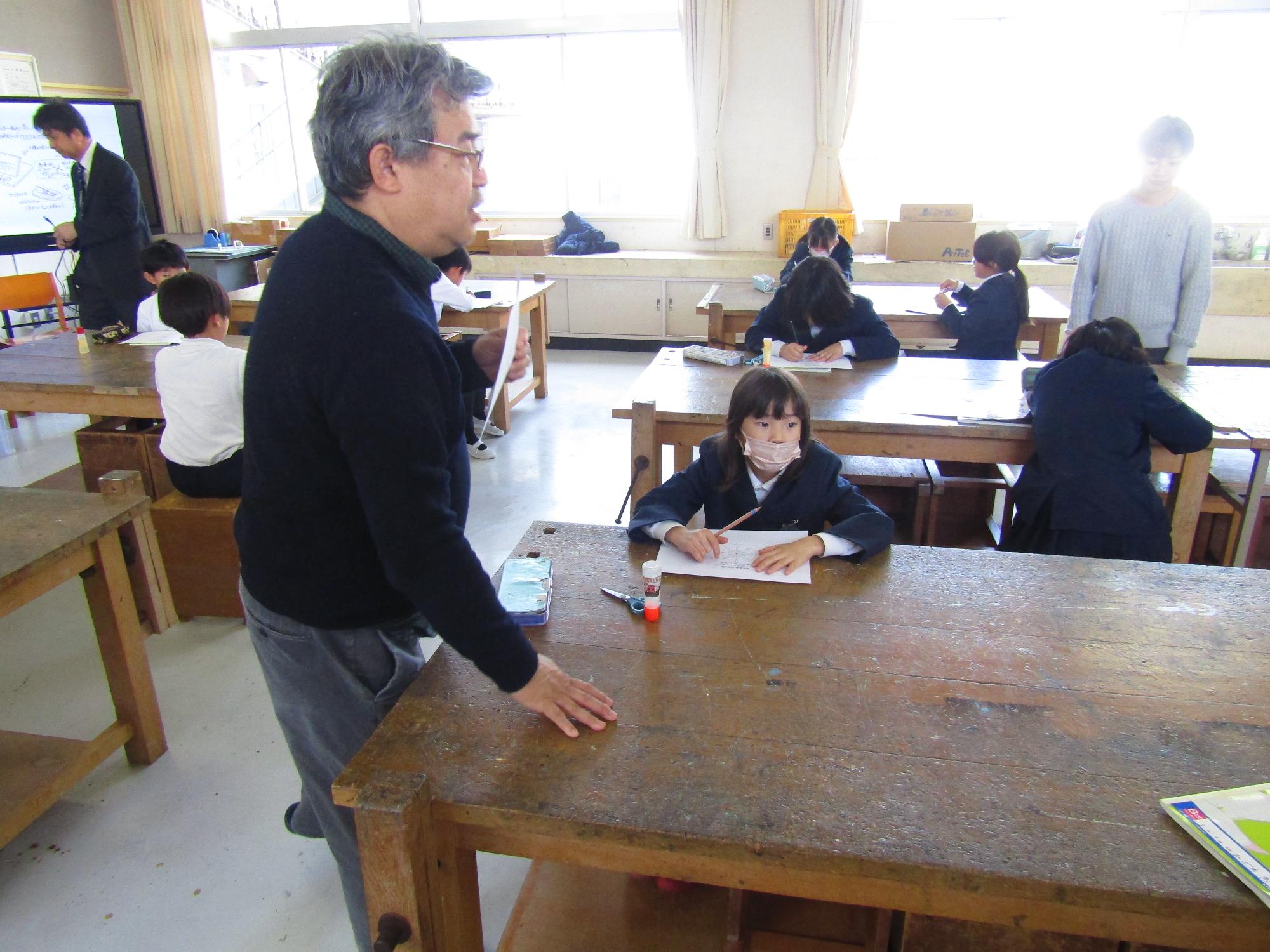 子どもたちのそばで説明をする准教授