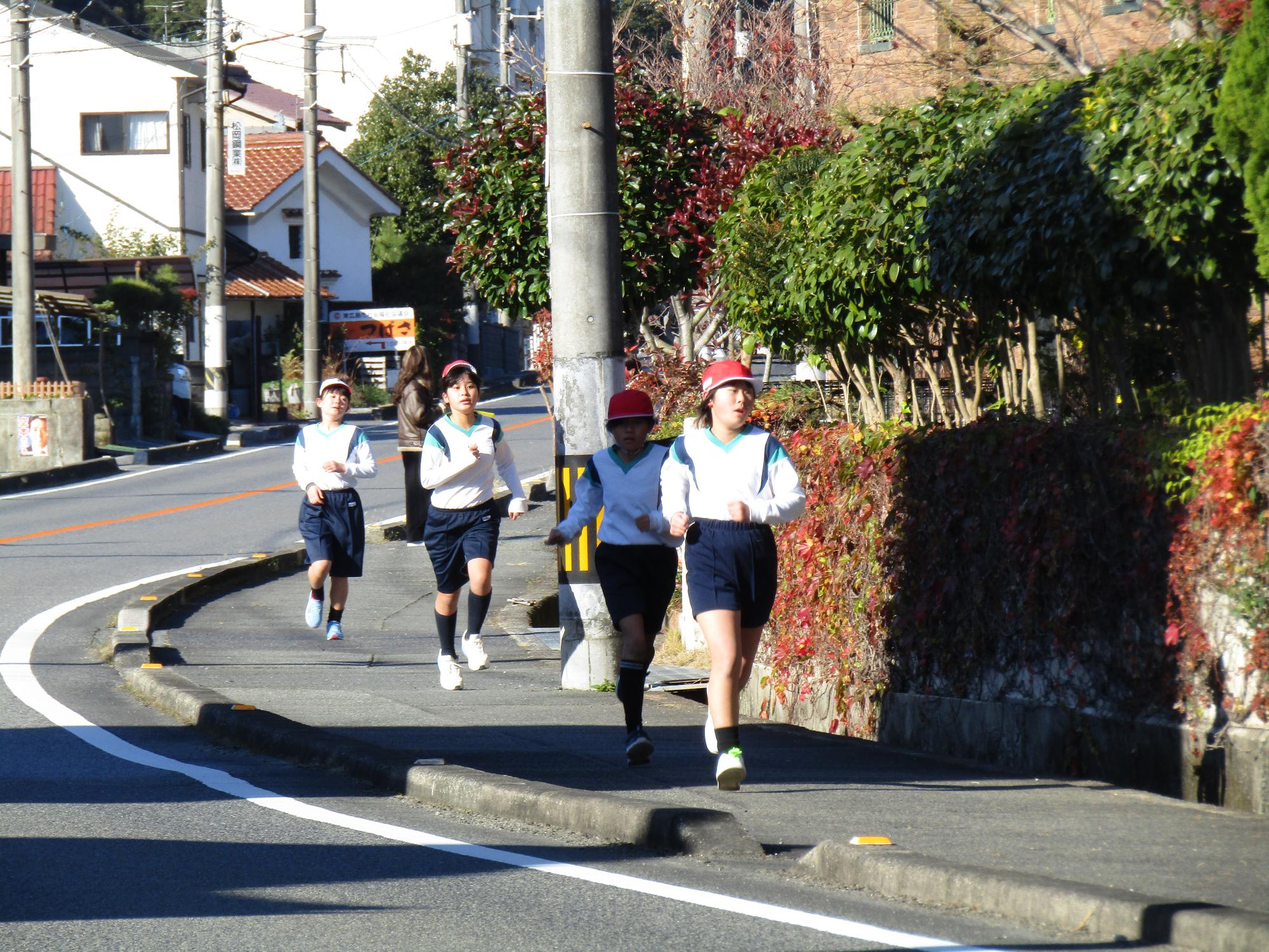 学校前の歩道を走る高学年女子の集団
