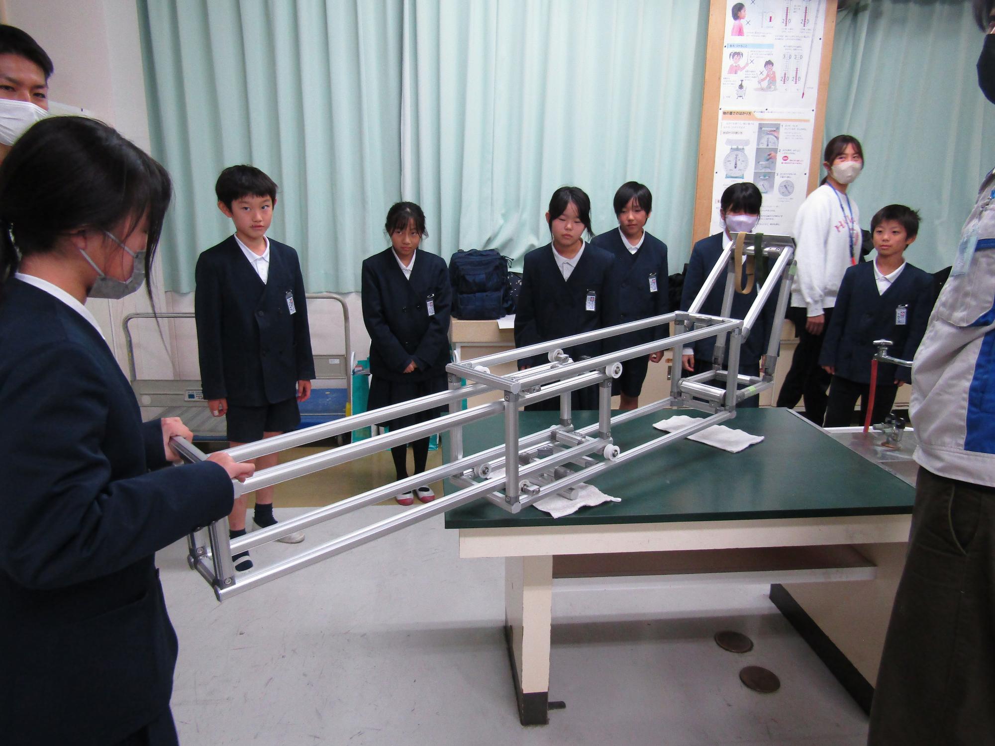 アルミパイプのアーム模型を使っている女子児童