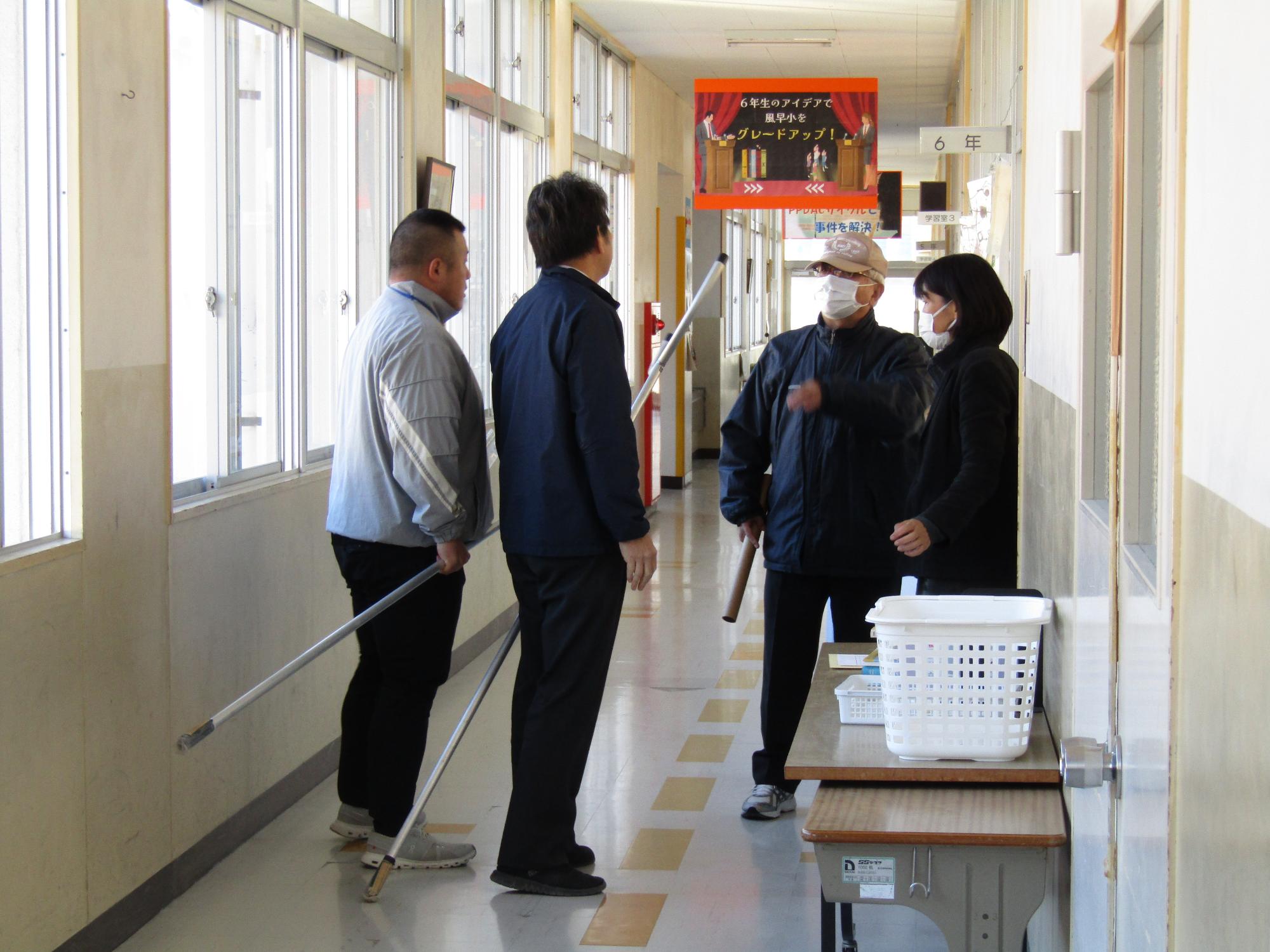教室前廊下で話し込む不審者役と教職員たち