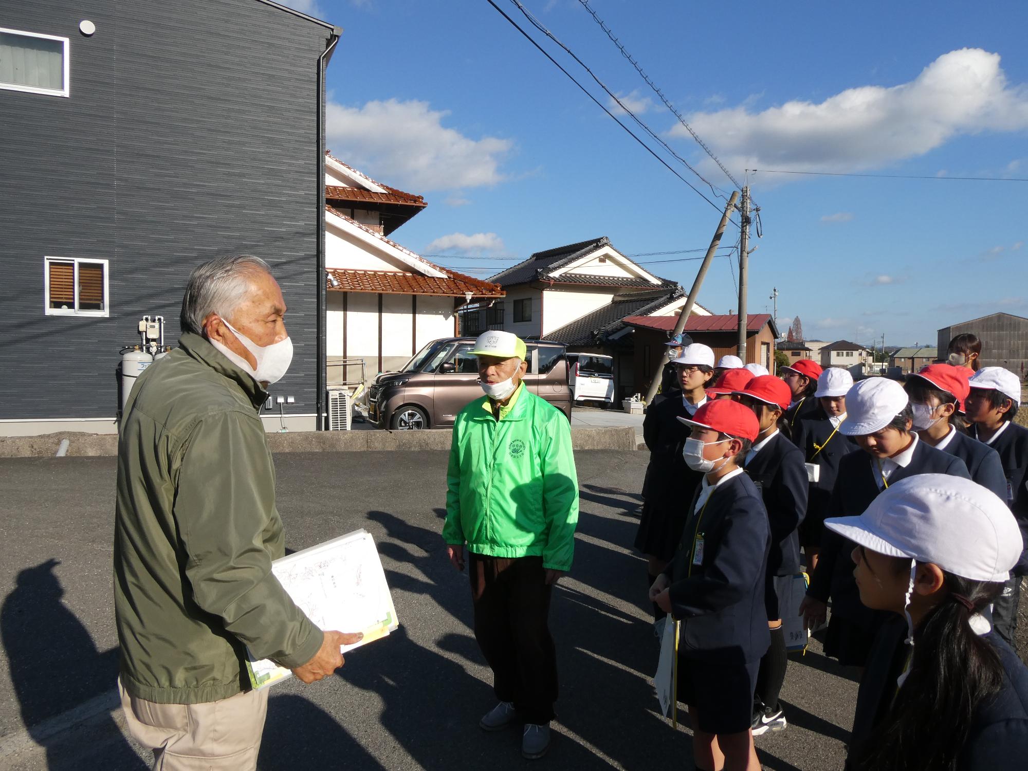 屋外で子供達に説明をする防災士たち