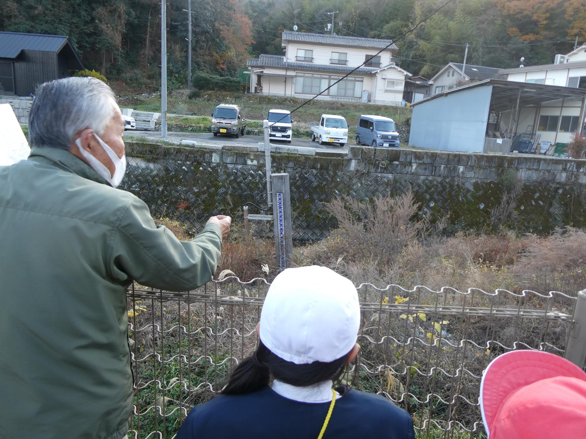 空地を指して説明する防災士