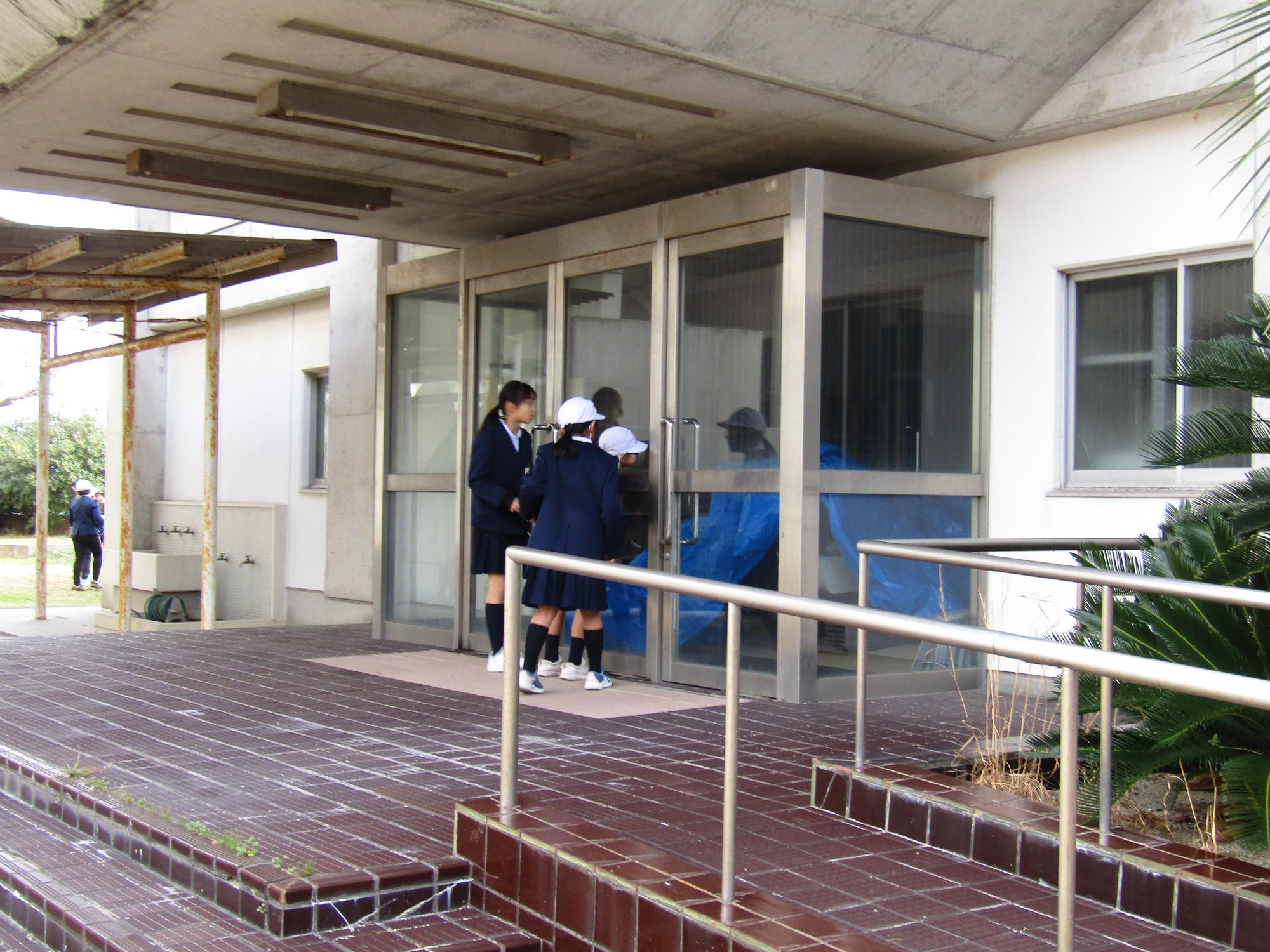 使われなくなった体育館をのぞき込む児童たち
