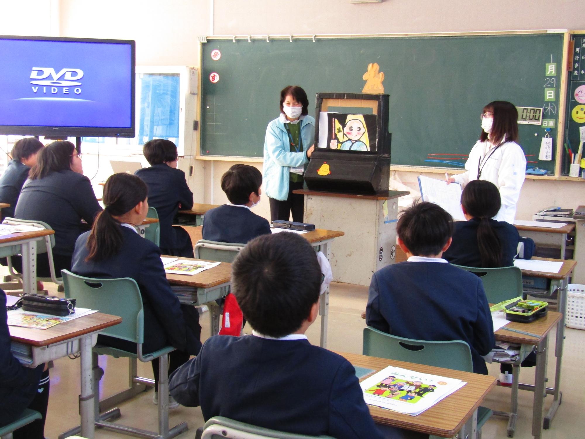 手作りの紙芝居を見る子供たち