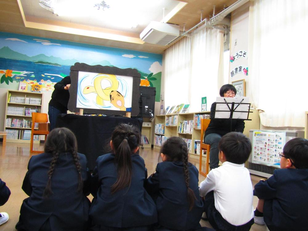 大型紙芝居を座って見ている子供達