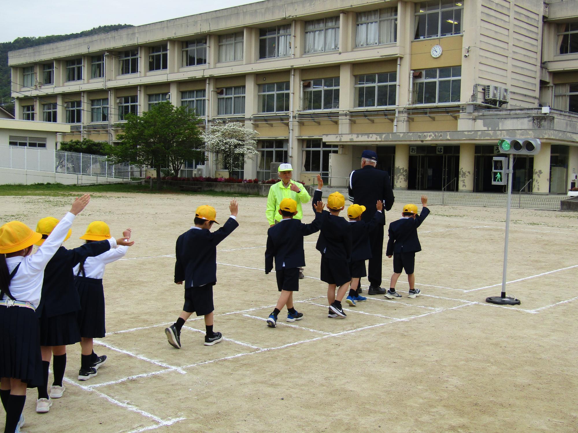 校庭に作られた信号機のある横断歩道で渡る練習をしている様子