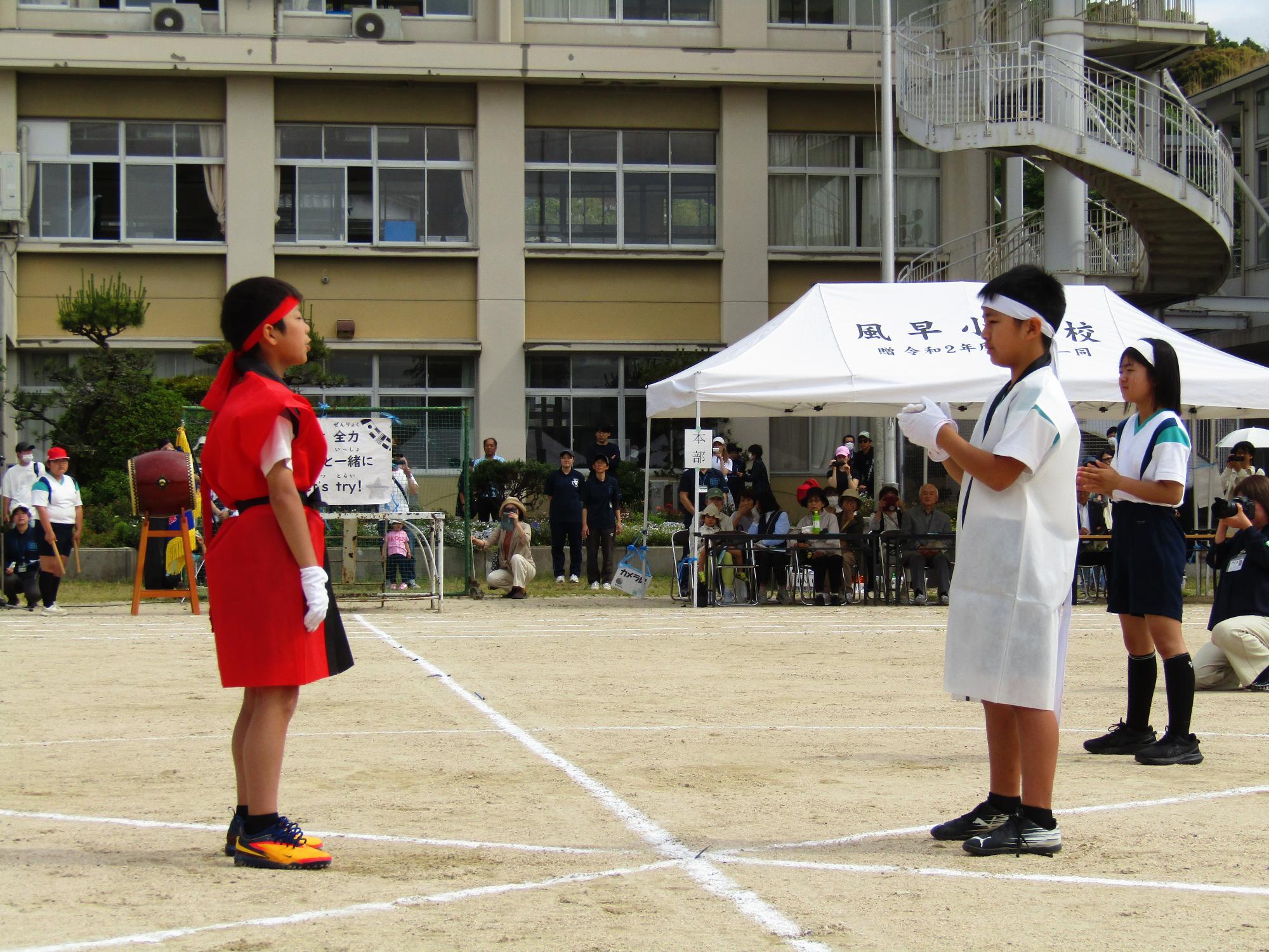 赤団と白団の団長が向かい合って立っている
