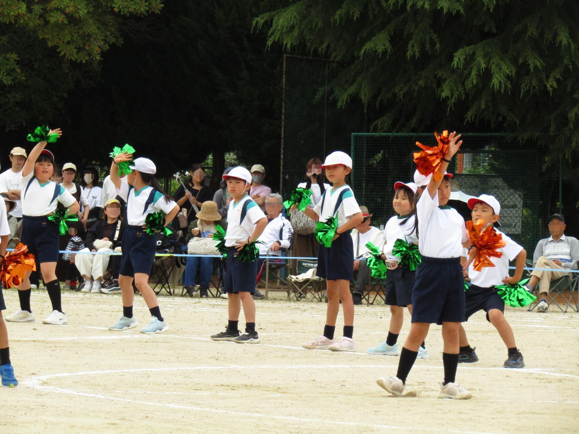 キラキラしたポンポンをつけて踊る1、2年生