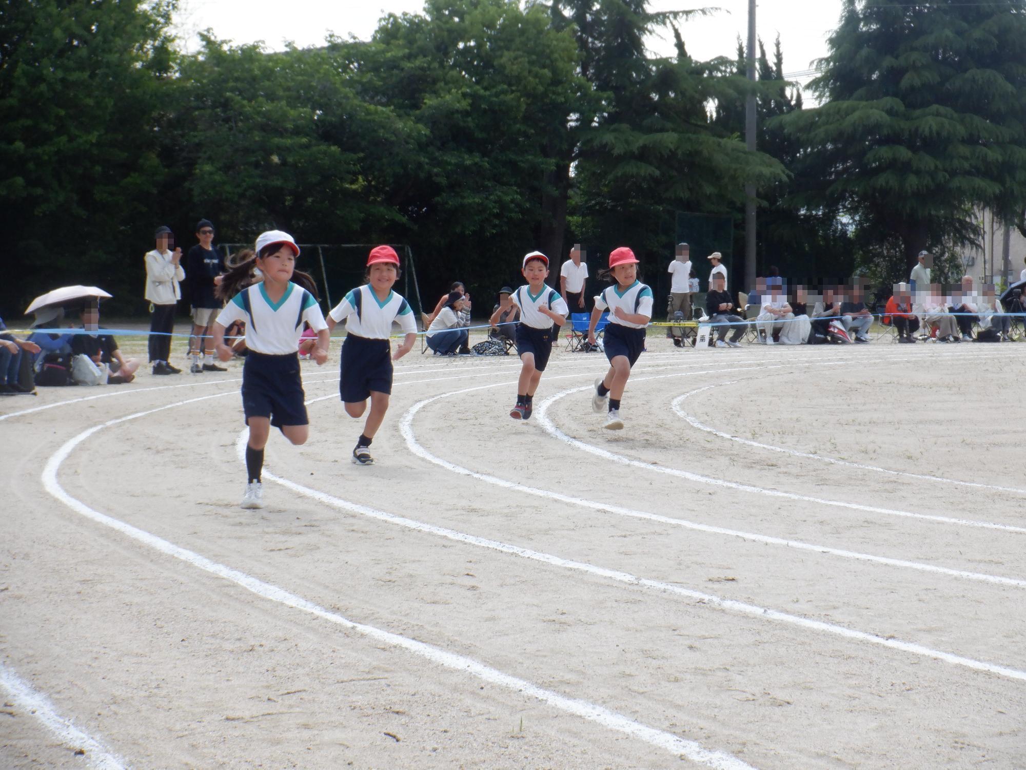 コーナーを走る4人の女子児童