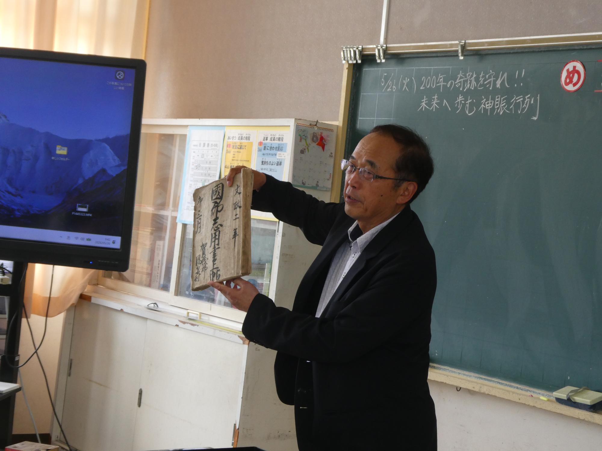 古書を提示して説明する宮司さん