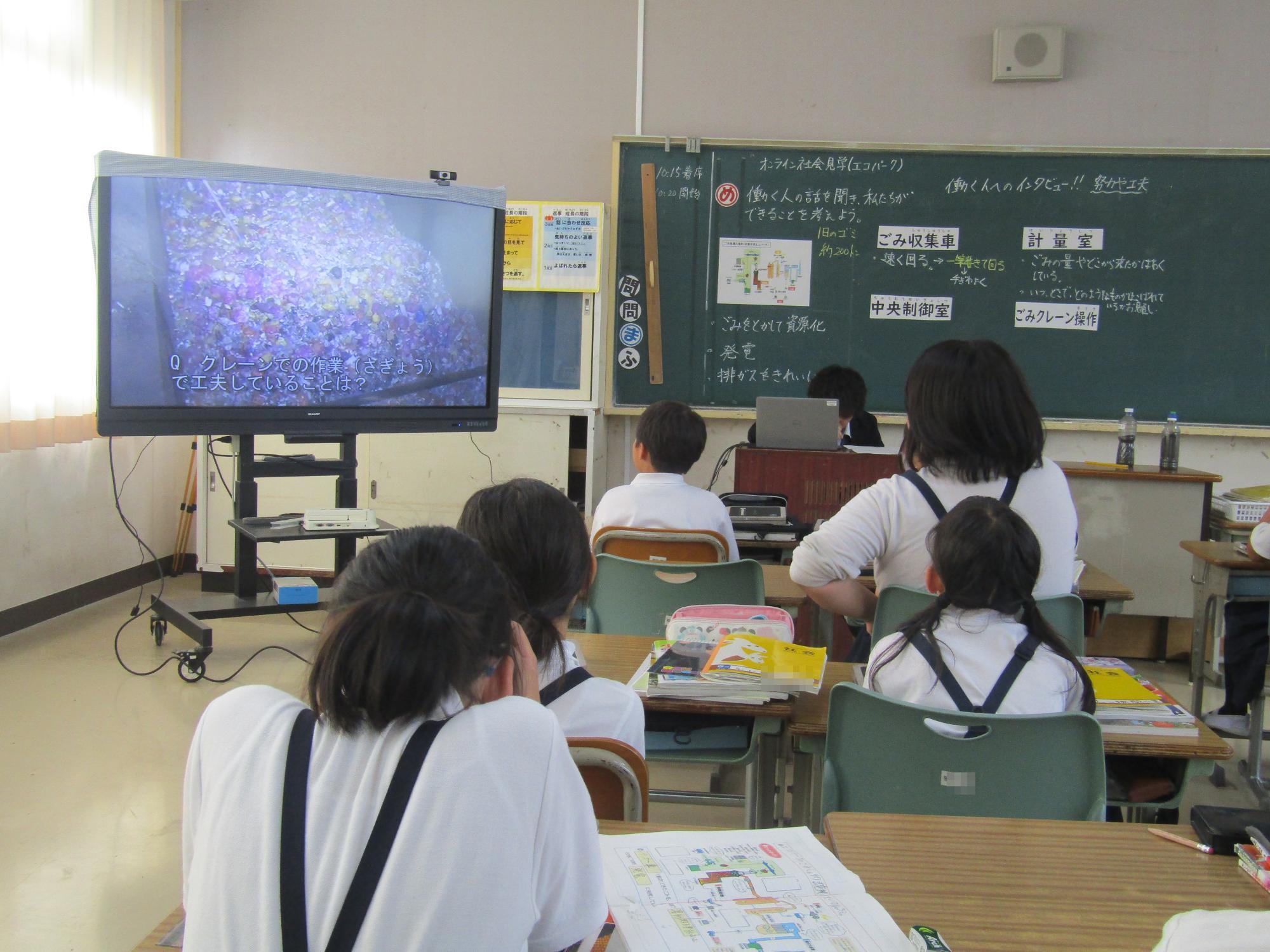 電子黒板に映るごみ処理の様子を見ている児童