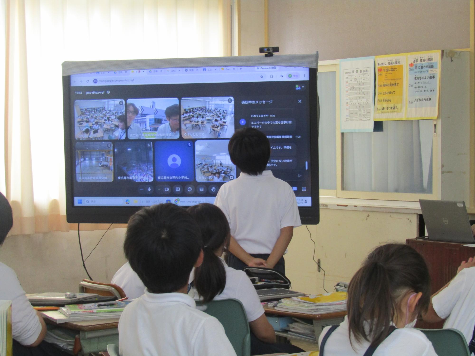 電子黒板に向かって発表する男子児童