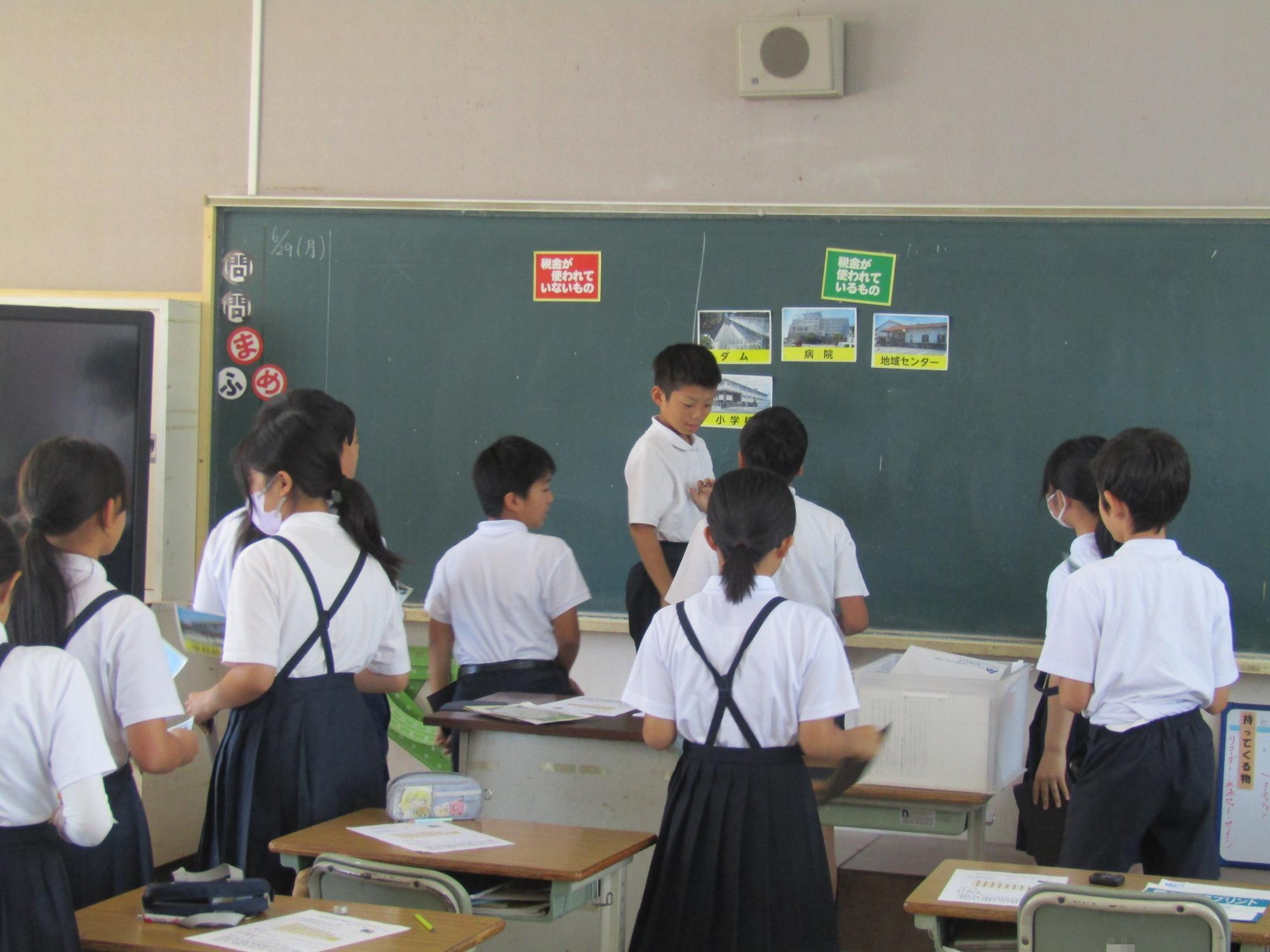 自分たちの考えを黒板に貼っていく様子