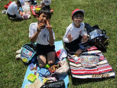 敷物をひいて子ども達がお弁当を食べています。