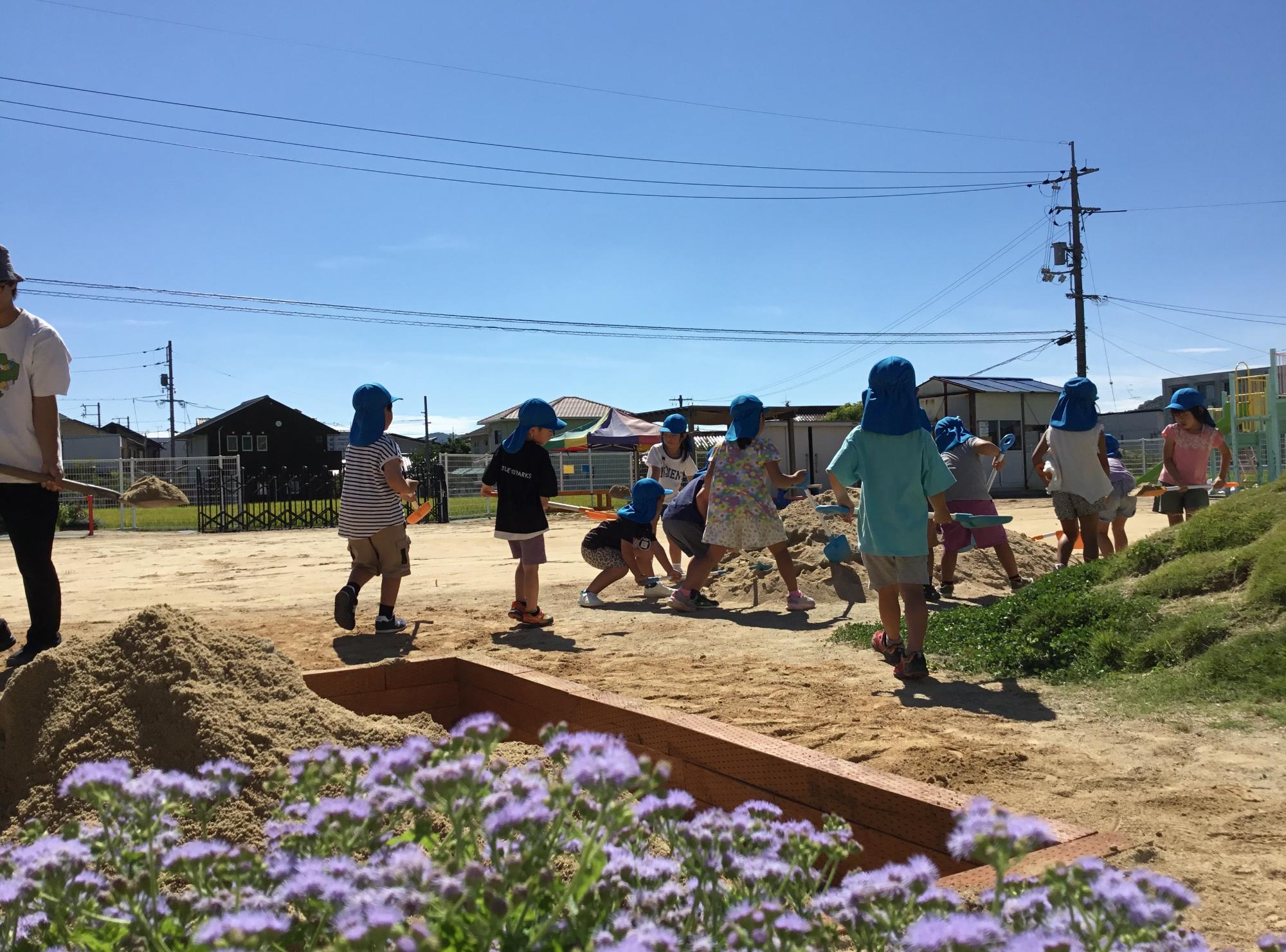 年長クラスの子ども達が園庭作りの作業をしている写真