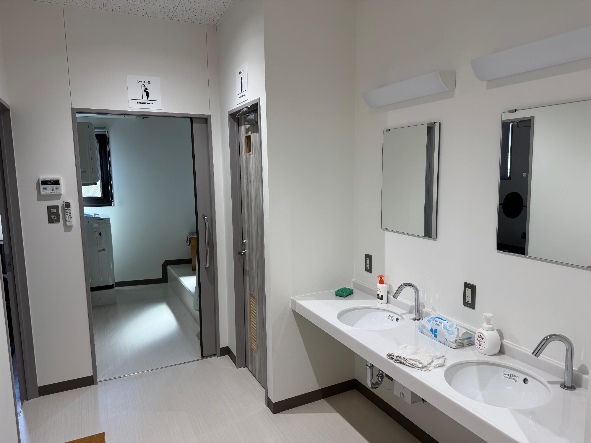 脱衣所と洗面所の写真 手前に洗面所があり洗面所の奥には脱衣所があります。