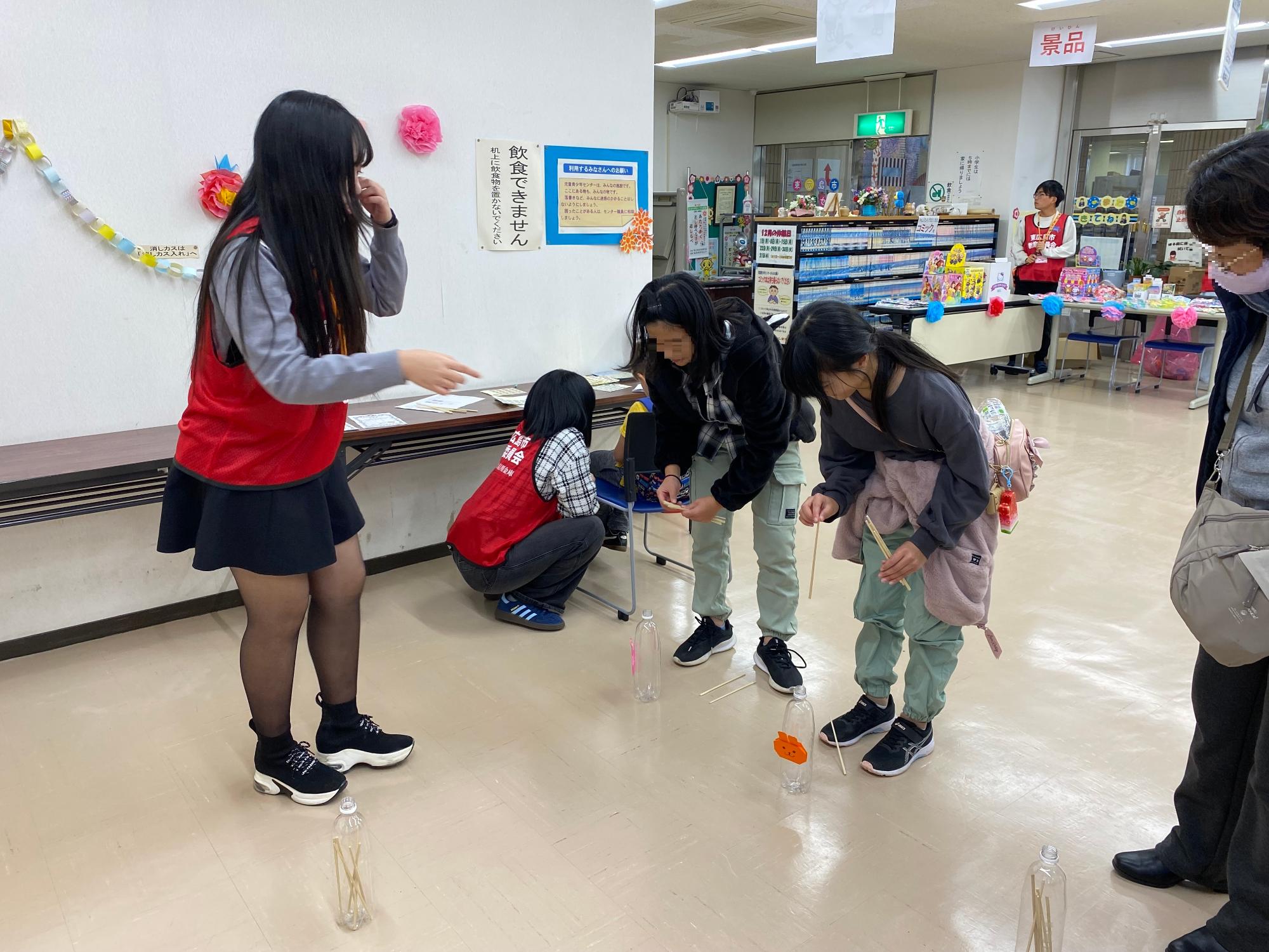 ペットボトルに棒を入れるようす